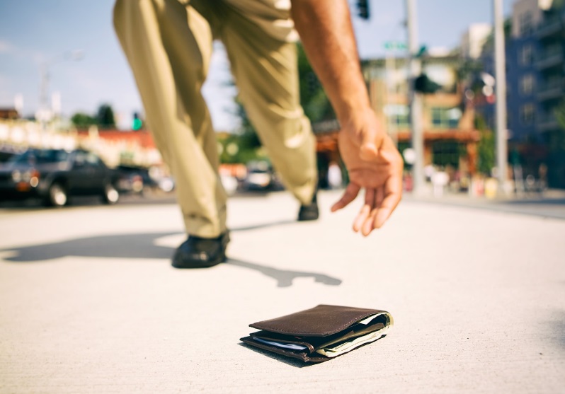 Tout savoir sur le 118 400 : le numéro pour faire opposition à votre carte bancaire Un homme ramasse un portefeuille au sol