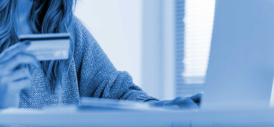 Cybermut : mieux comprendre ce système de paiement en ligne Femme avec carte bancaire et ordinateur