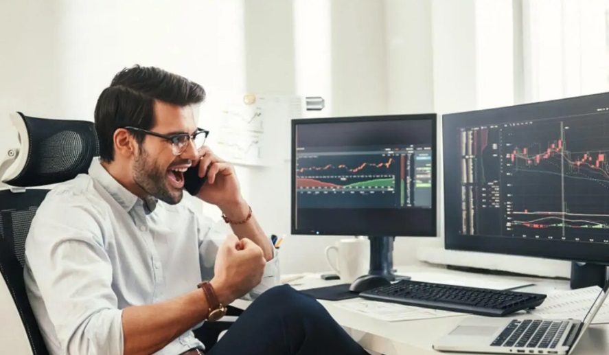 Trader des cryptomonnaies : 3 indicateurs pour réussir Homme heureux devant ordinateurs