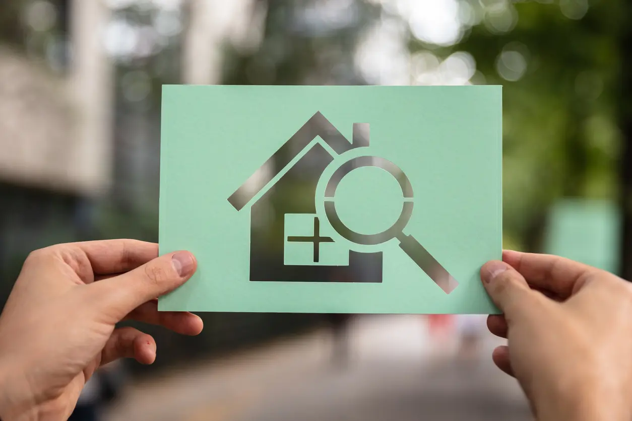 Maison en papier avec une loupe