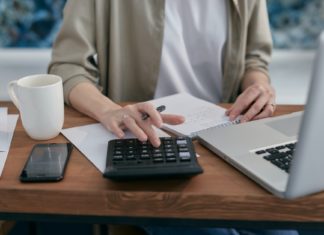 Quels enjeux pour le rachat de crédit en 2022 ? femme utilise calculatrice pour faire ses comptes de crédits