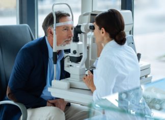 Pourquoi et comment choisir une mutuelle optique ? Homme agé en consultation chez un opticien
